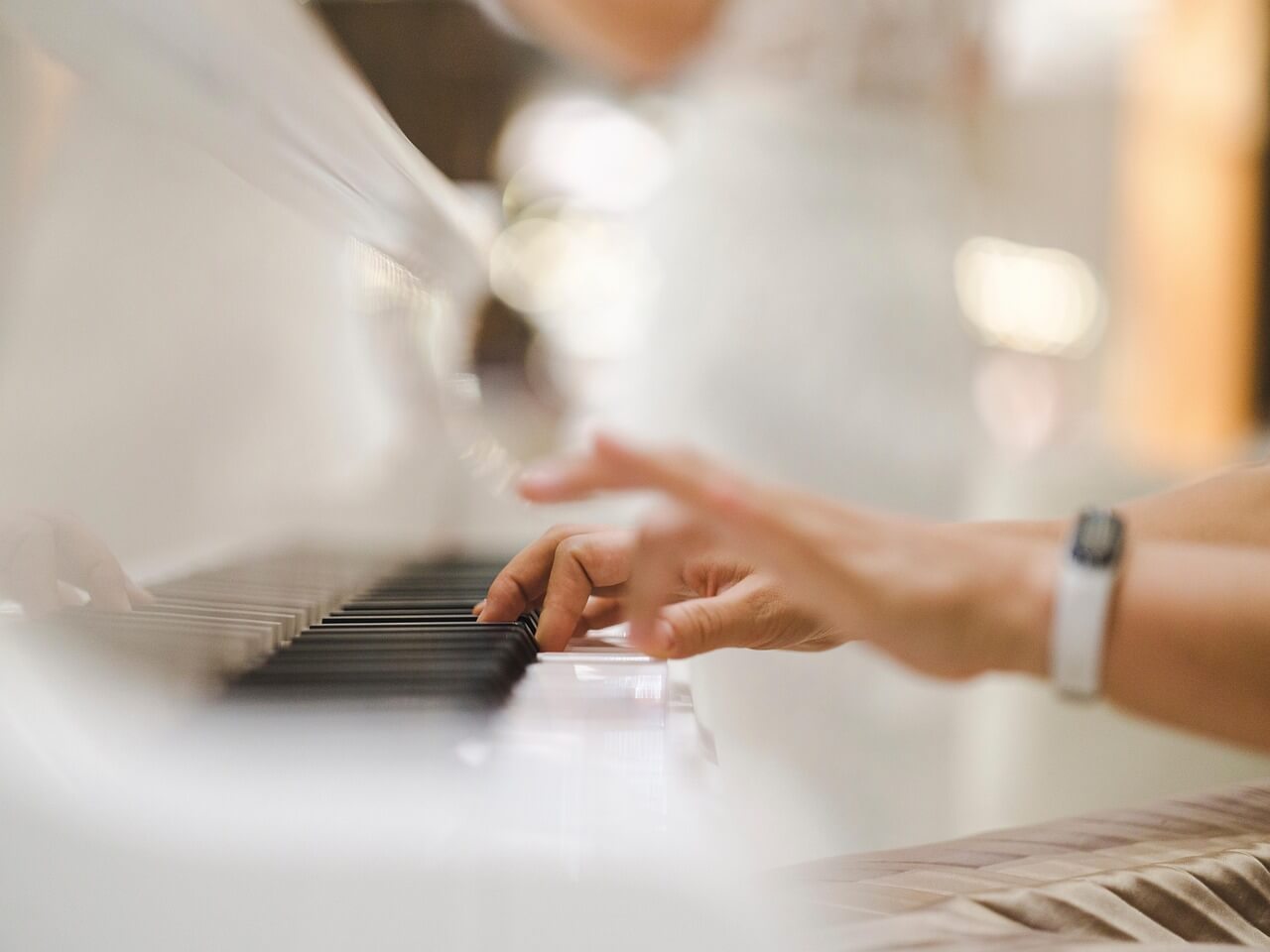 Pianistin sormet koskettimilla kesken esityksen. Tunnelmallinen pianomusiikki luo juhlaan elegantin ja lämminhenkisen ilmapiirin.