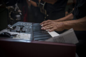 Aikuinen harjoittelemassa pianonsoittoa sähköpianolla ensimmäisillä pianotunneilla.